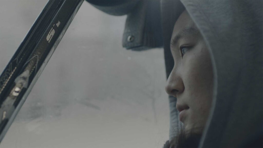 Choa, a female Korean ice hockey player, sits on a Seoul city bus early in the morning heading to the ice rink for a game, as the only woman on South Korea's men's team.