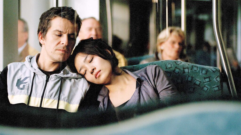 Poster Image of Finding Joy - Joy rests her head on Lukas shoulder as they journey by train in Berlin Germany