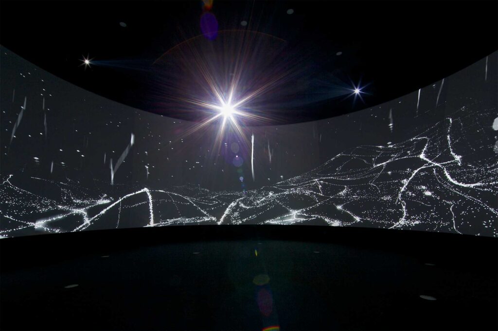 A 360 surround screening area within the GS Caltex building displays a landscape illuminated by lights, with a sky full of stars at night