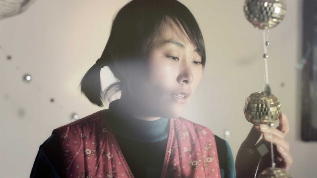 A scene from the Wolf + Lamb vs. Soul Clap 'Lonely C' music video: In a remote South Korean countryside village, the sister sings along to the lyrics of the song while the record plays on the record player beside her in her room