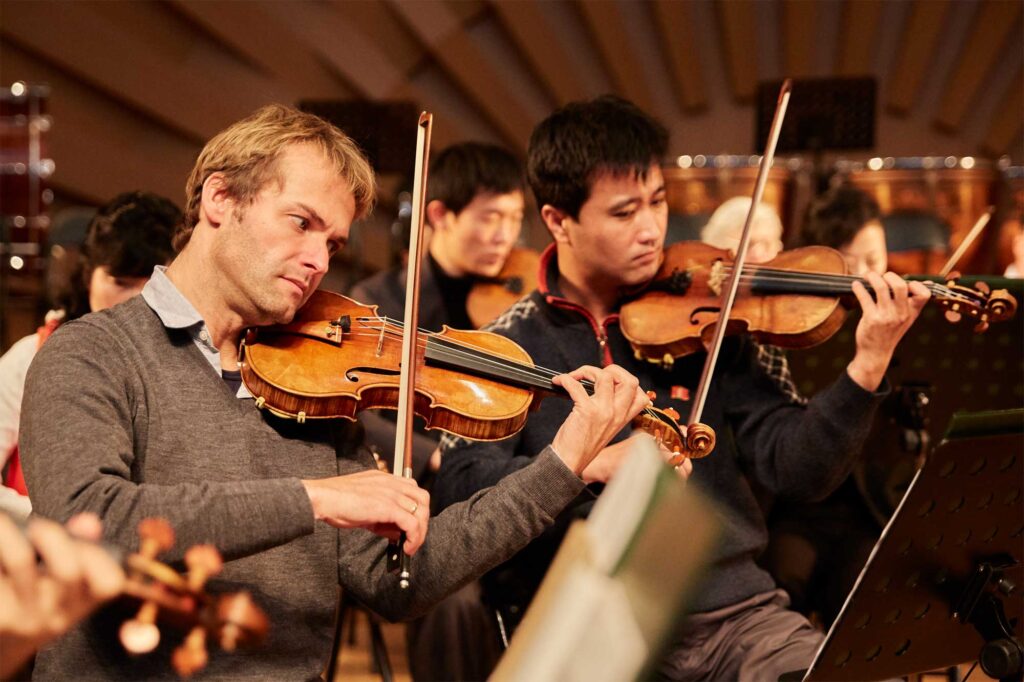 Violinist from Munich Chamber Orchestra practicing with students at Pyongyang Kim Won Gyun Conservatory in North Korea