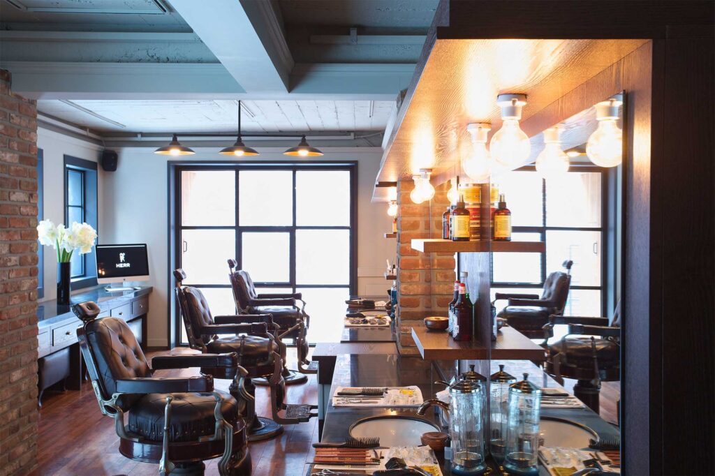 Interior of the gentlemen's barber shop HERR in Seoul, South Korea, with three vintage barber chairs in a row and an array of grooming tools spread across the counter.
