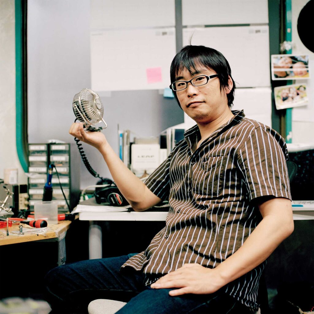 Mechanic at Tokyo workspace, opts for desk fan over air-con to conserve energy post-Fukushima