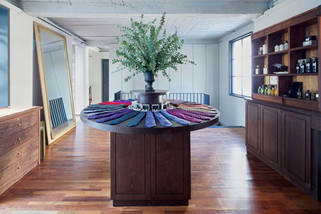 The second floor accessory area of the gentlemen's barber shop HERR in Seoul, South Korea, showcasing a range of ties, buttons, creams, and oils for sale.