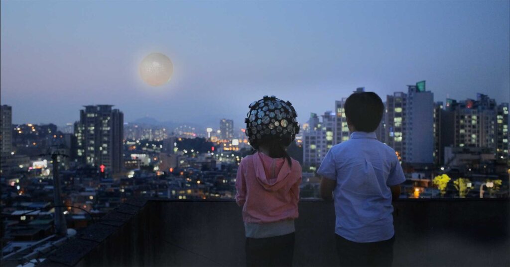 M83's Moonchild music video showing two kids on a rooftop in Seoul, wearing a special space helmet, watching the moon and dreaming of space travel.