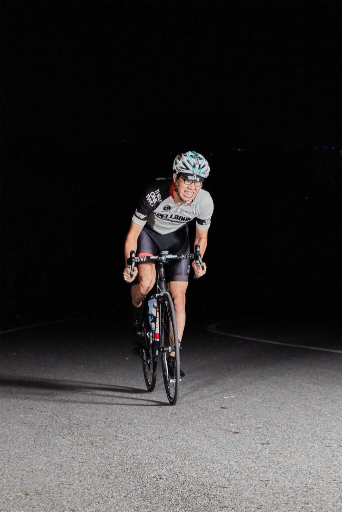A professional Korean cyclist works hard as he climbs a mountain road at night in the northern part of Seoul, South Korea