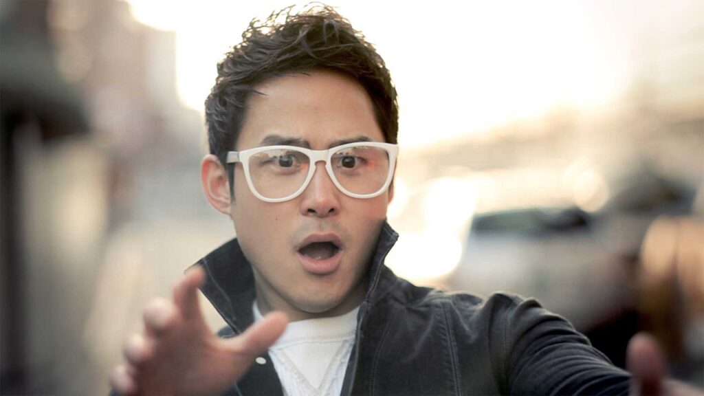 A scene from Röyksopp's 'Senior Living' music video: A young man reacts in shock as he sees a pair of chopsticks flying towards him during a battle with an older man.