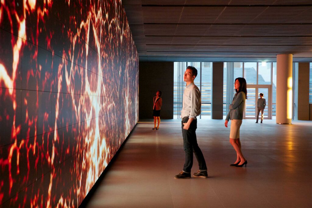 Wide shot from the side of the Vision Hall Media Wall with visitors looking at the moving art piece by Universal Everything at Hyundai Motor Group University, Mabuk Campus, South Korea