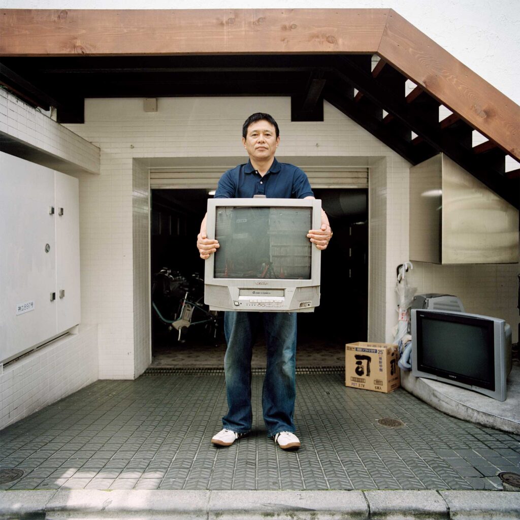 Man discards old TV outside Tokyo garage, conserving energy post-Fukushima