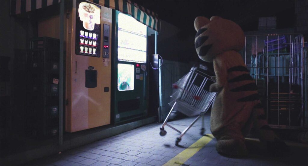 Lost cat vents frustration by throwing a shopping cart at a vending machine in Nana-D's 'Lose Against You' music video