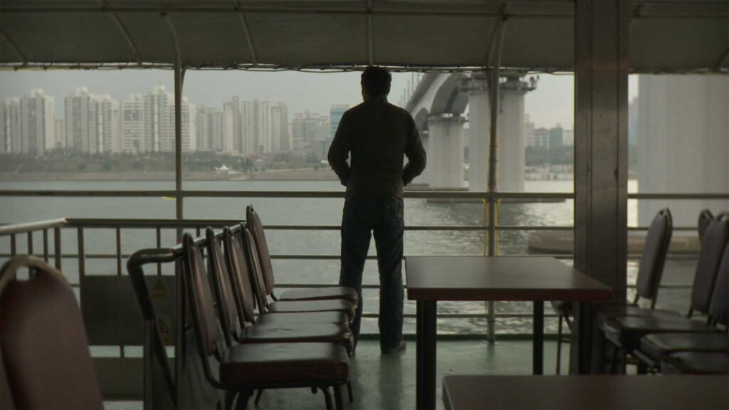 Lukas (Crisjan Zöllner) stands on a cruise boat on the Han River in Seoul, South Korea