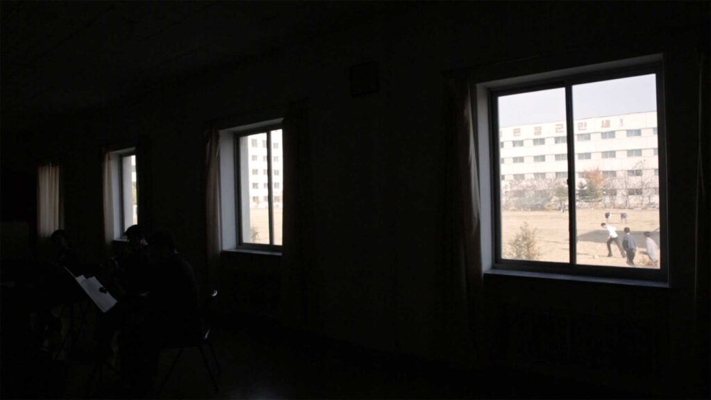 Kim Won Gyun Conservatory schoolyard with students playing soccer during break, Pyongyang, North Korea