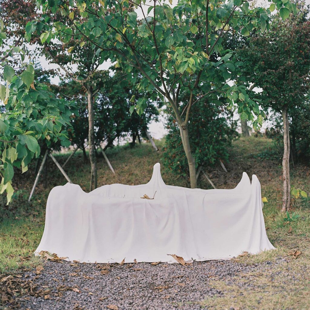 A sculpture of a man on a death bed covered by a blanket in Loveland sculpture park, Jejudo Island, South Korea
