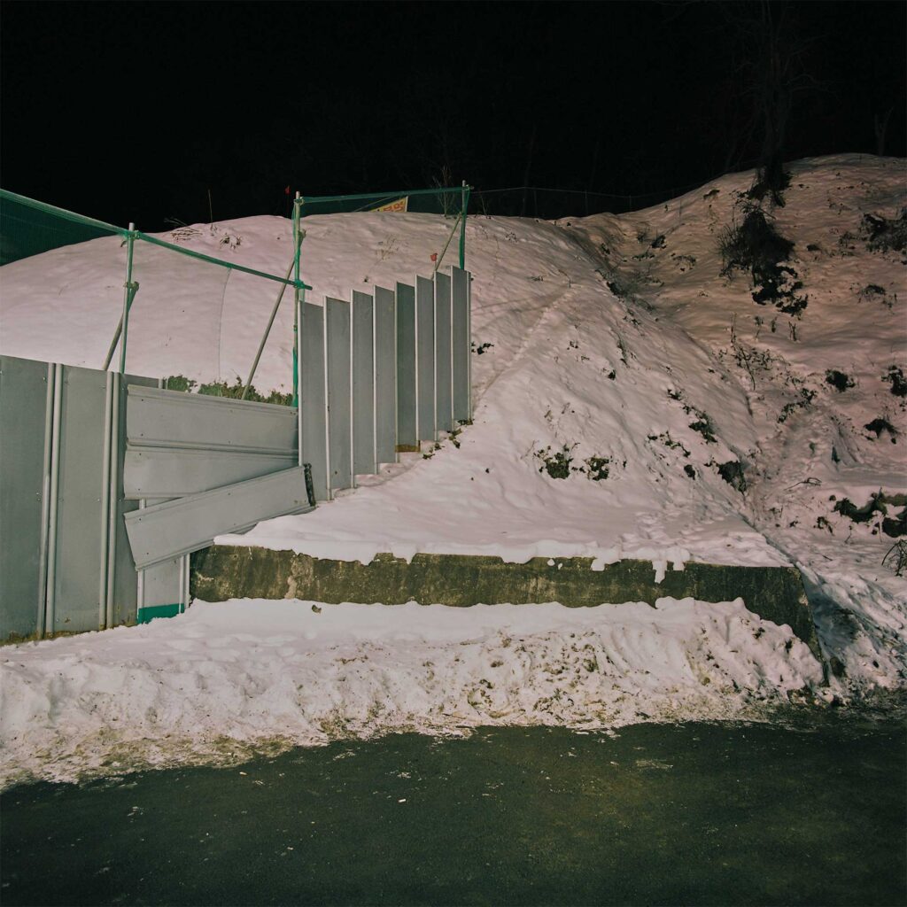 Fenced-off construction site on a hillside outside Seoul at night