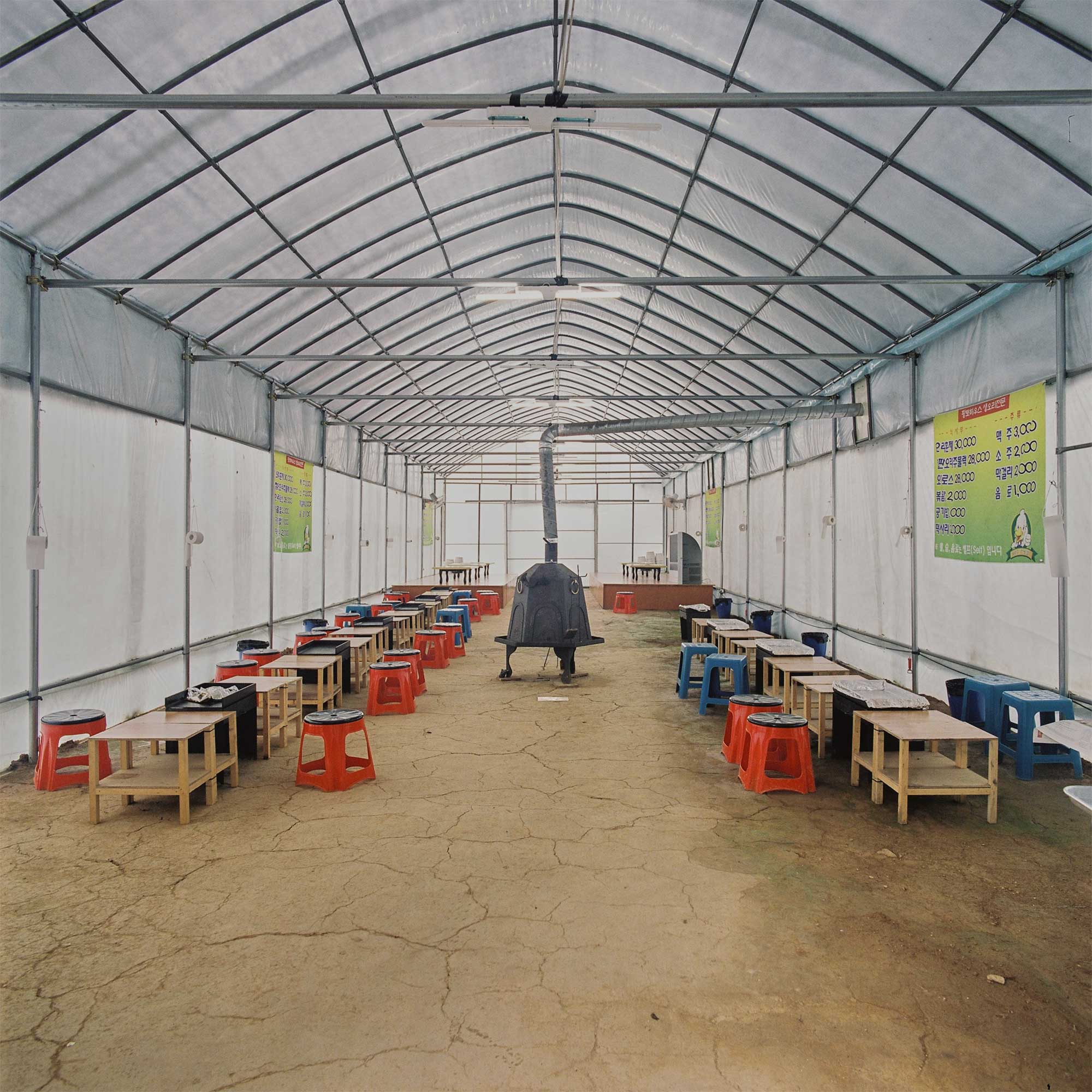 A greenhouse transformed into a pop-up restaurant with a central oven heater