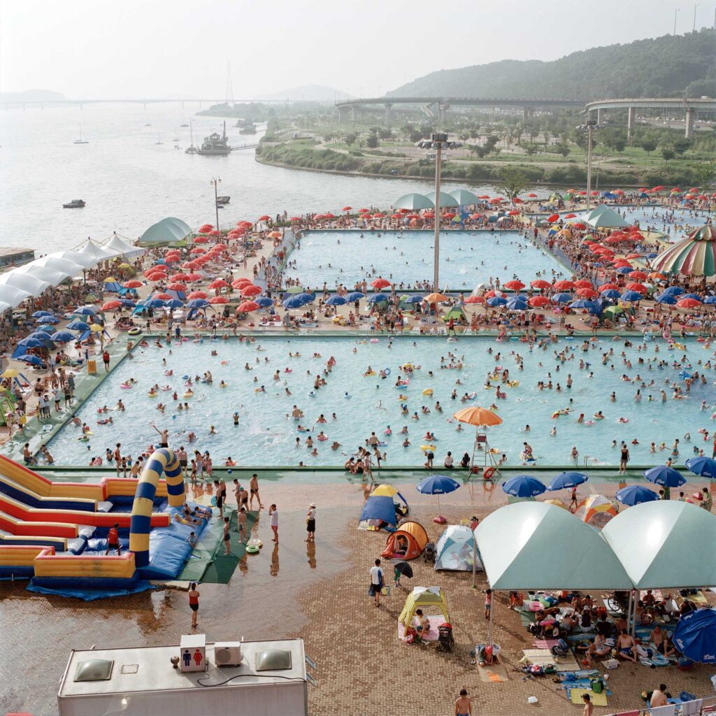 People enjoying a refreshing dip in the crowded public pool on a hot summer afternoon next to the Han River in Seoul, South Korea