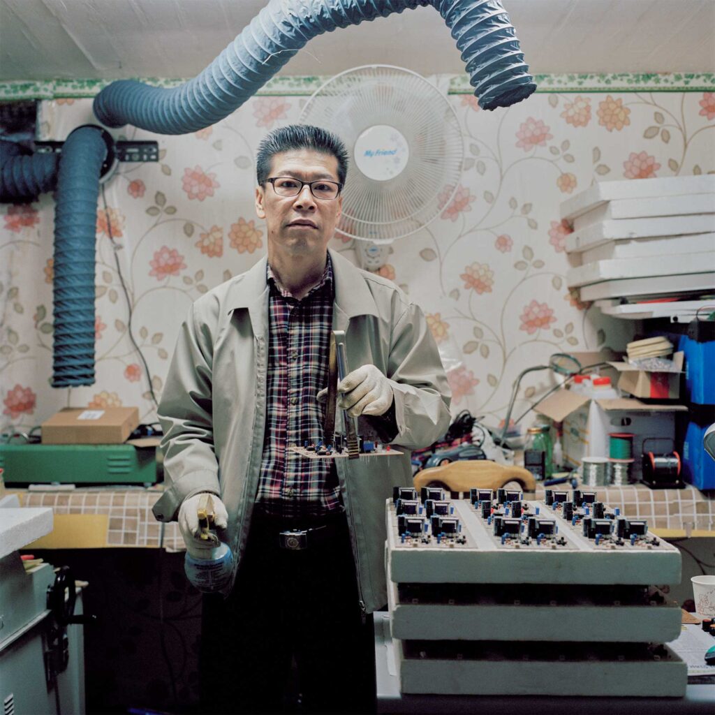 A Korean man at work, focusing on computer chips in a workspace near Dongdaemun, Seoul, South Korea