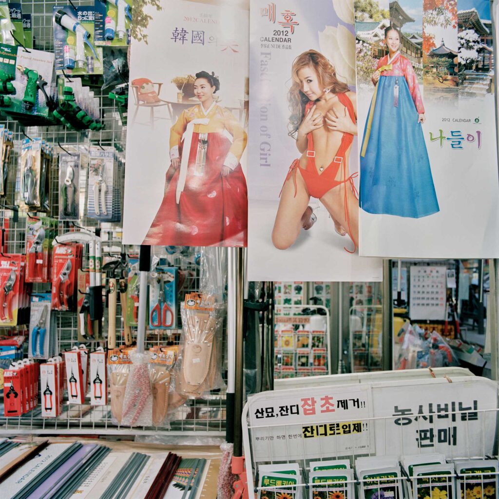 Inside a shop in Seoul's Jongro district, traditional calendars juxtapose with risqué imagery, reflecting cultural contrasts