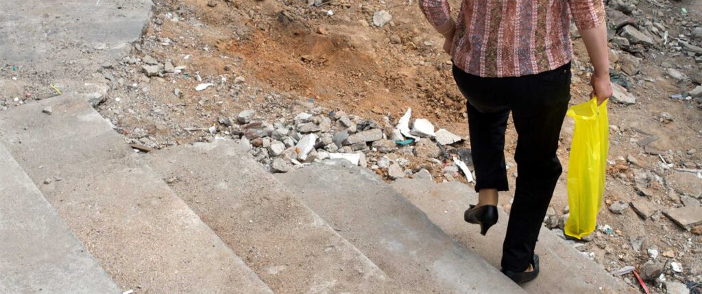 A woman walking down a staircase into a demolished neighborhood of an urban reconstruction apartment project in Seoul, South Korea