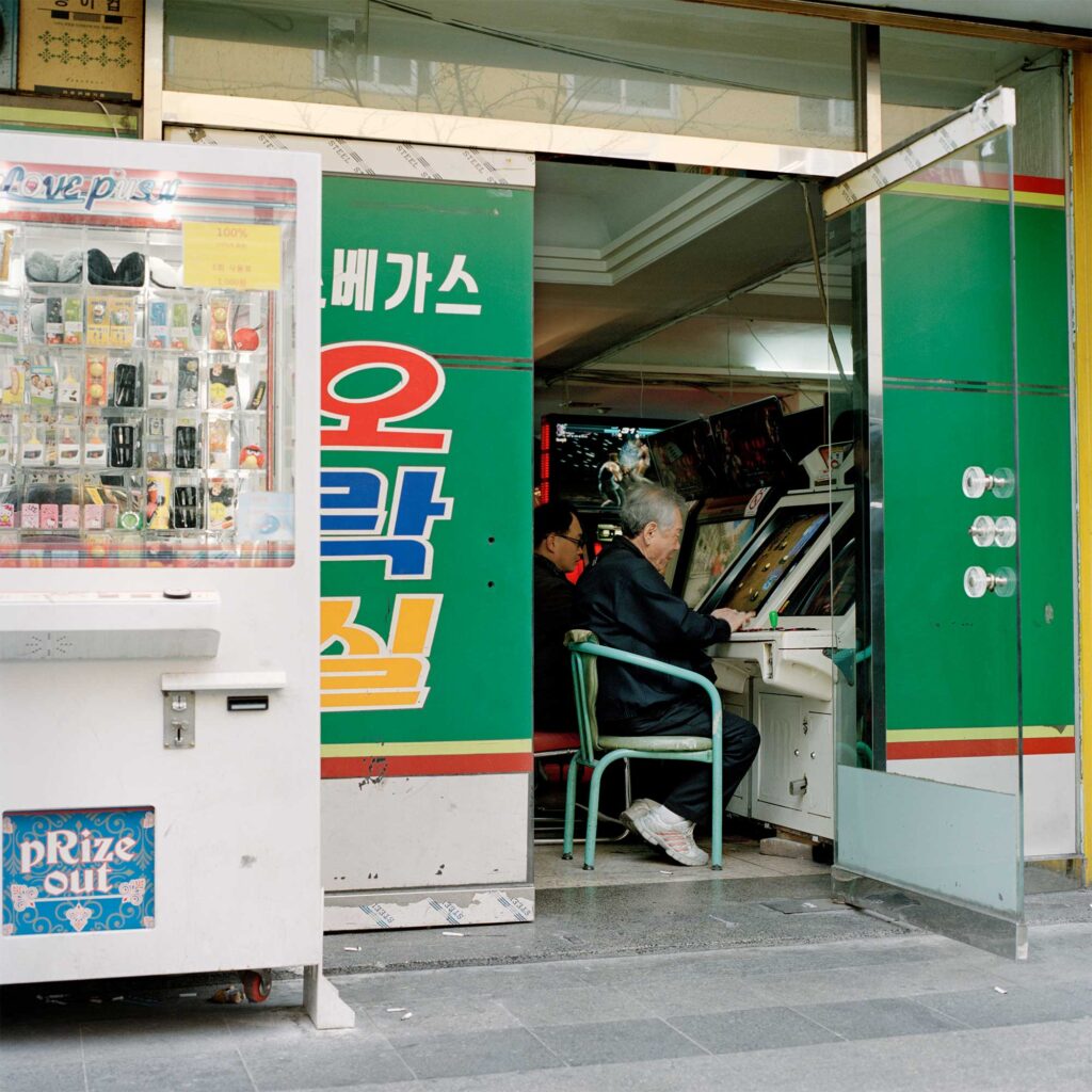 In Jongro district, Seoul, an open door of a gaming hall reveals an old man gaming freely near the entrance