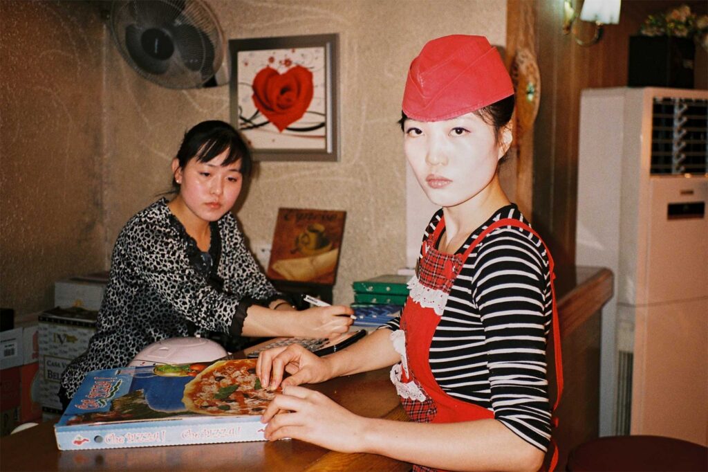A female staff member at an Italian pizza restaurant in Pyongyang, North Korea, packs pizza into a cardboard box