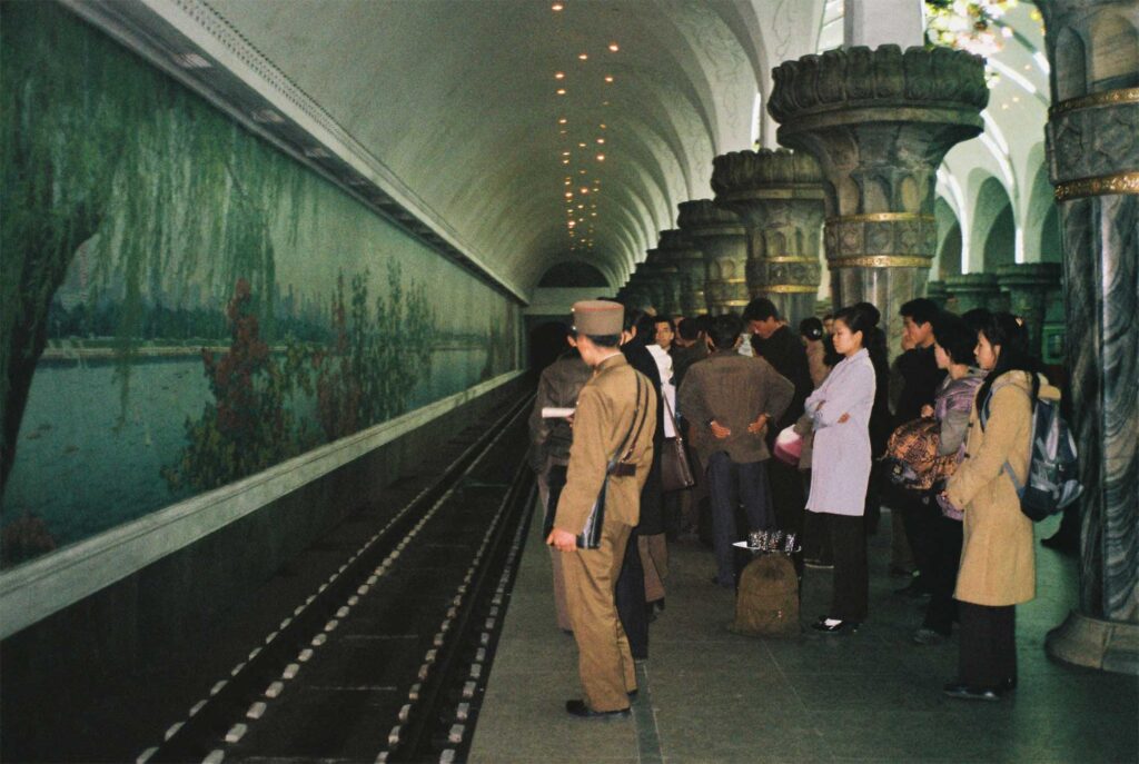 People wait on a bustling platform at a subway stop in Pyongyang, North Korea, anticipating the arrival of the train