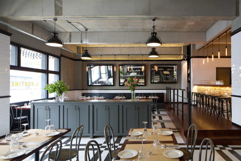 Interior of Libertine bar and restaurant in Itaewon, Seoul, featuring a modern design with minimal decor, using mainly concrete and tiles.
