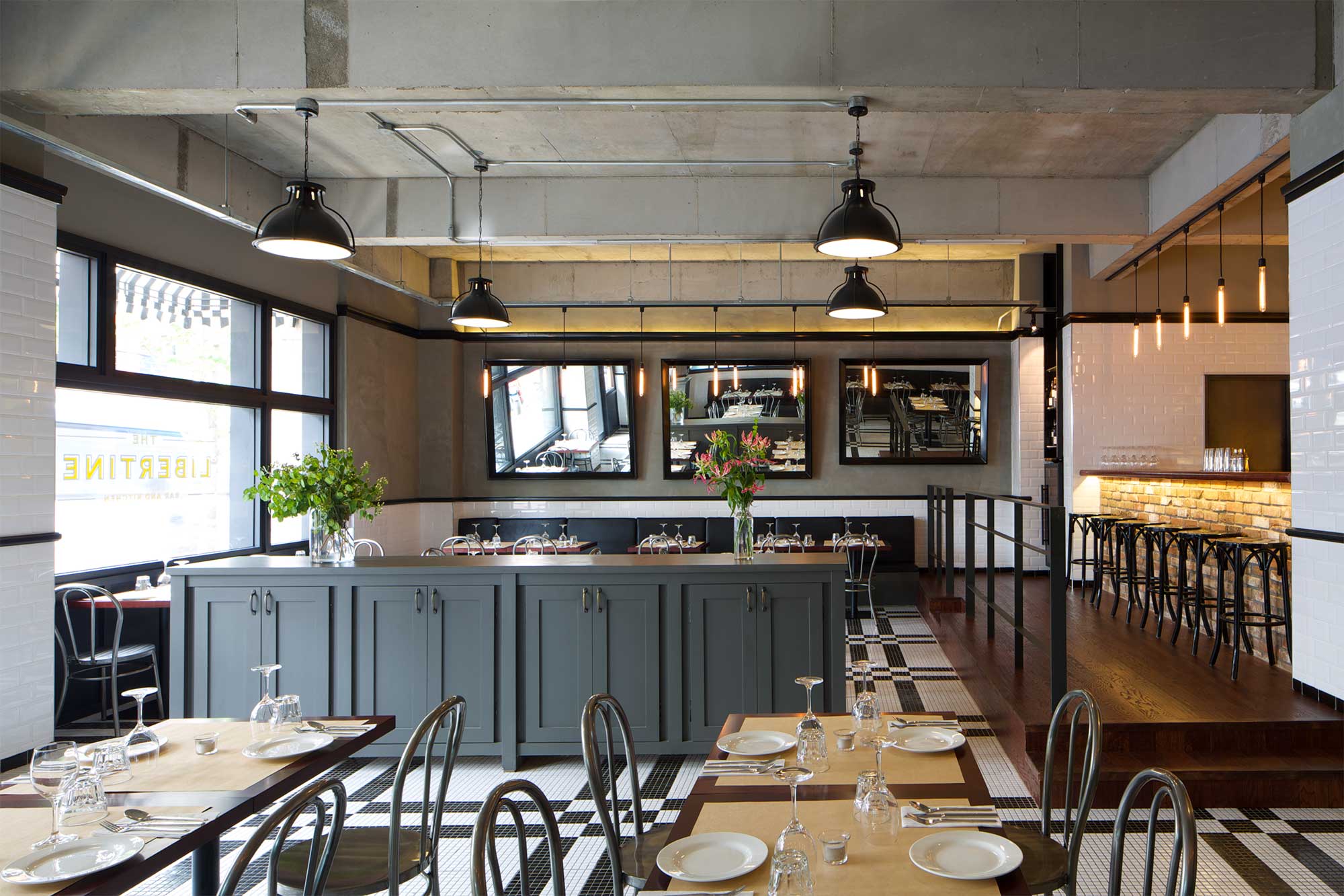 Interior of Libertine bar and restaurant in Itaewon, Seoul, featuring a modern design with minimal decor, using mainly concrete and tiles.