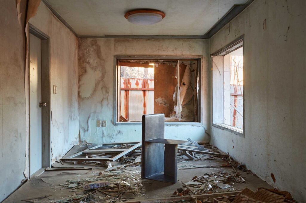 A lacquer-coated bronze furniture piece by Korean artist Kwangho Lee, winner of the 2013 YÉOL Young Craftsman Award, set in an abandoned home.
