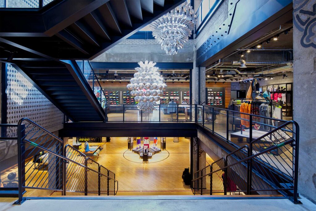 An impressive staircase with a stunning chandelier divides the ground and first floors at Nike's largest store in Korea, showcasing the latest sportswear in Gangnam, Seoul.