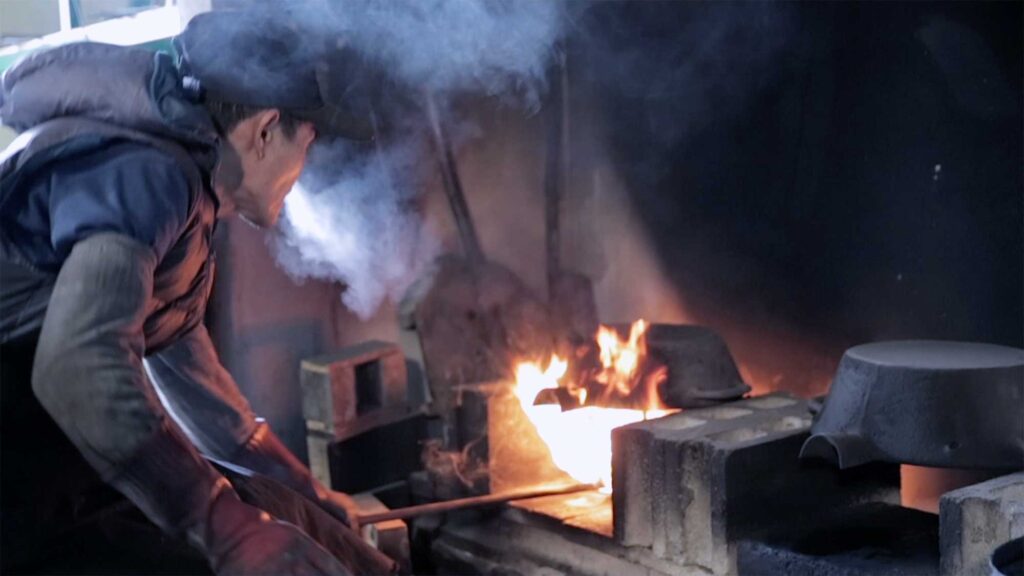 Korean craftsman Soo-Young Kim, winner of the YÉOL Award for Craftsman, intensifies the heat to forge his brass kitchenware above an open fire on a cold winter's day.
