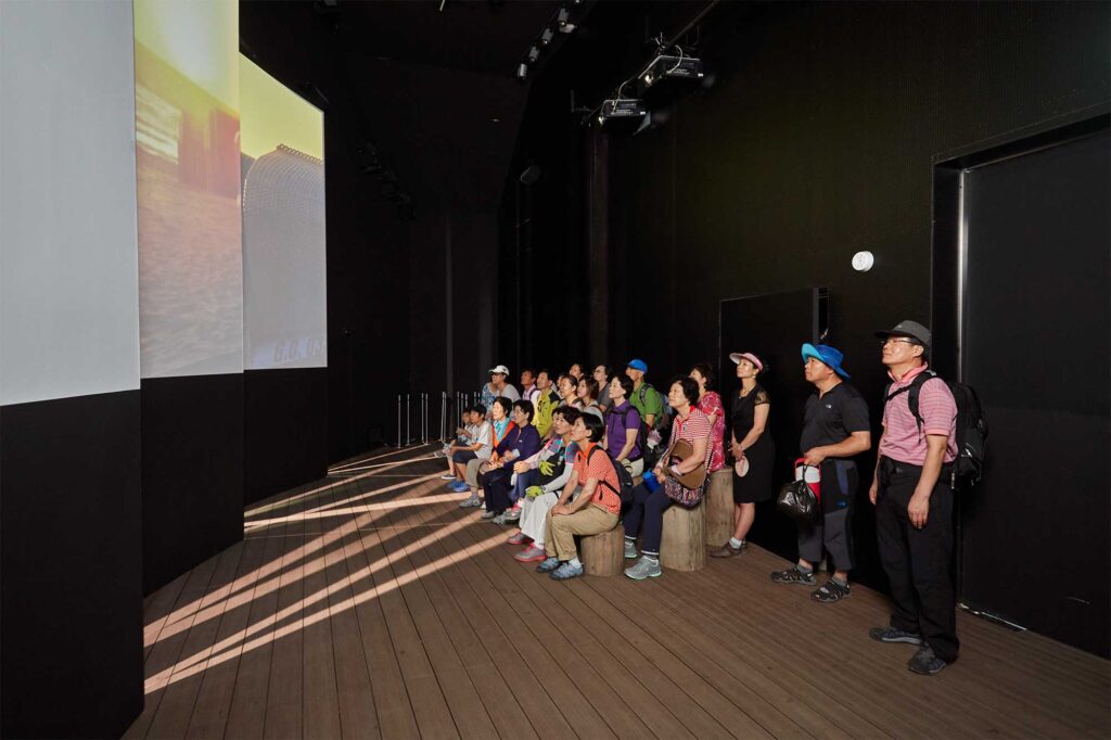 A group of people gathered for a video screening illustrating Germany's relationship to the ocean at the German Pavilion during Germany’s National Day at the World Exhibition in Yeosu, South Korea.
