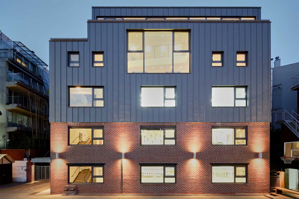 Exterior view of Deutsche Schule Seoul International (DSSI) showing modernized facilities designed by Zabel & Partners Architects, with strong color concepts representing each building.