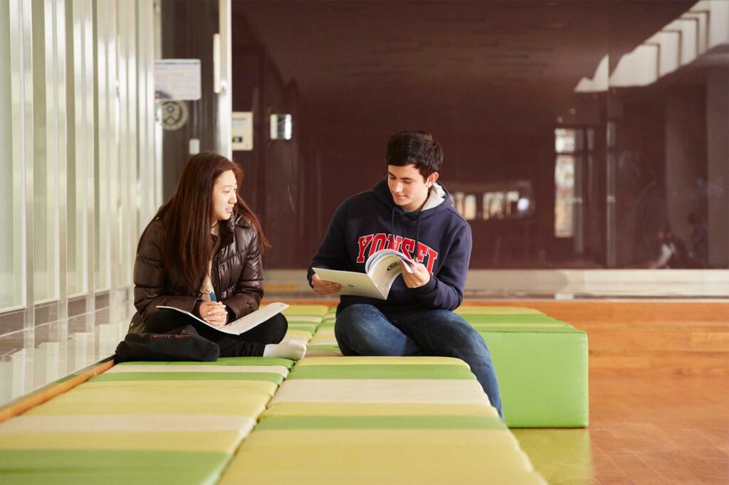 Two students discuss an assignment in a lounge area at Underwood International College, Yonsei University, Incheon Songdo Campus, South Korea.