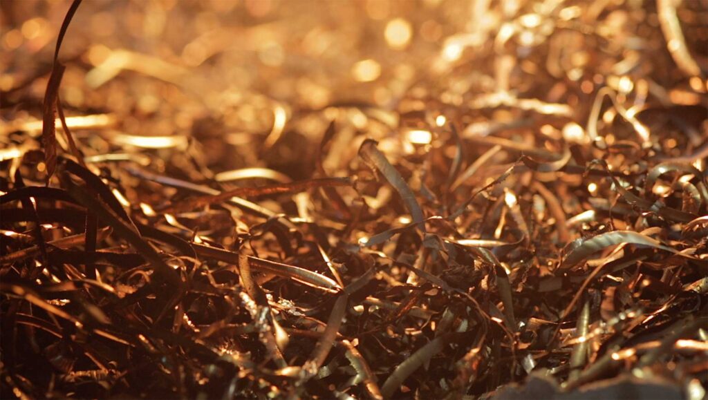 Golden shiny brass kitchenware splinters scattered on the floor during the grinding process by Soo-Young Kim, winner of the YÉOL Award for Craftsman.