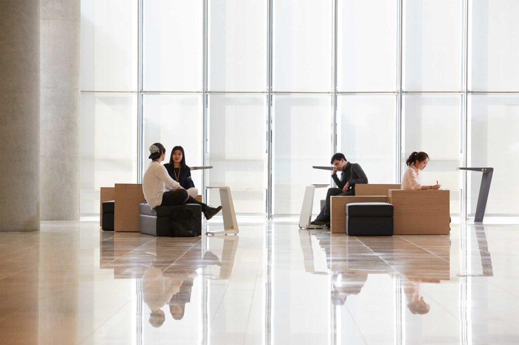 A couple of Underwood International College students study and relax in a modern, spacious hall at the Songdo campus of Yonsei University, Seoul, South Korea.