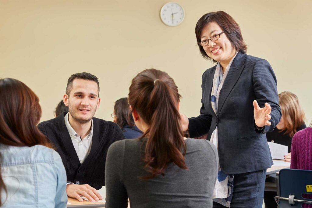 A group of Underwood International College students discusses their presentation with the dean in a classroom at Sinchon campus, Yonsei University, Seoul, South Korea.