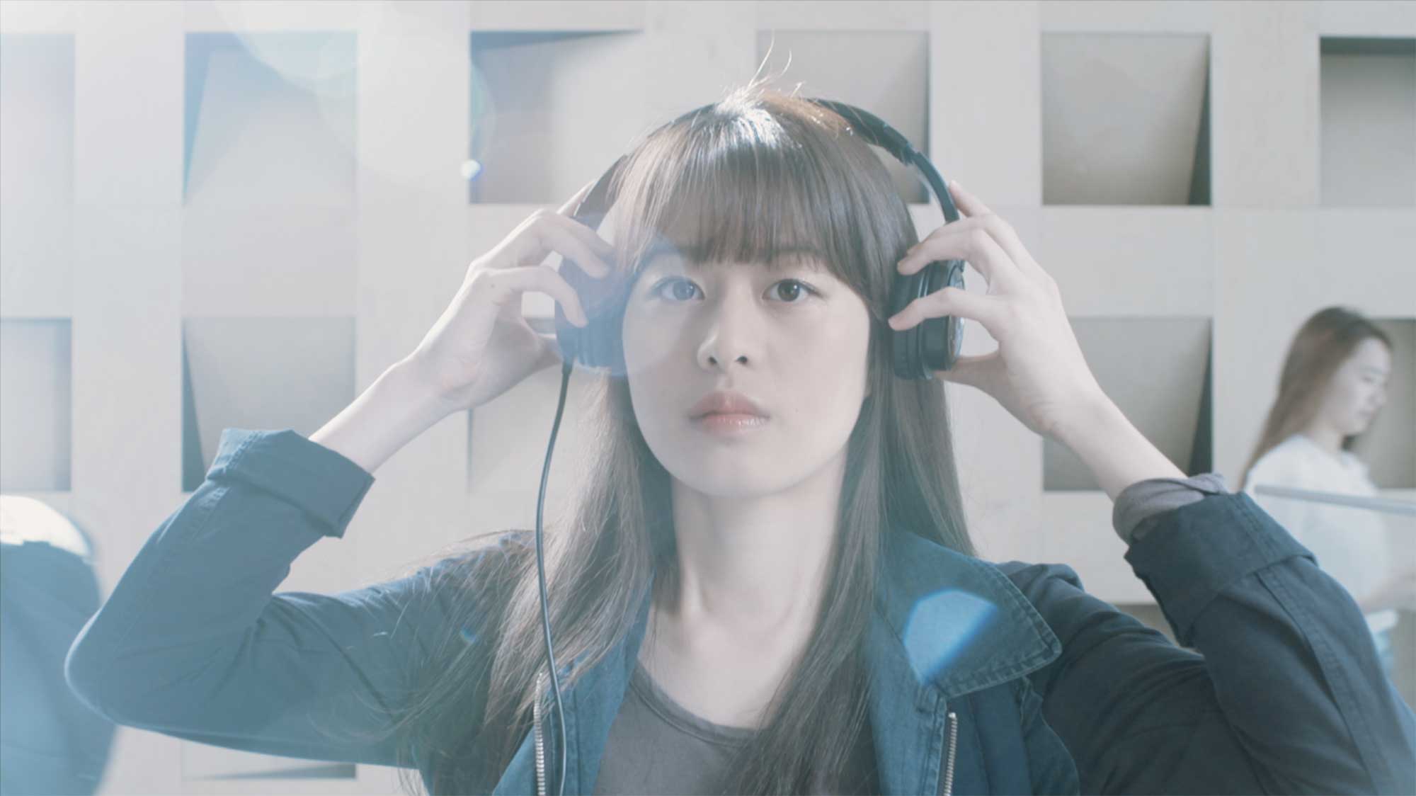 An Underwood International College student in a hall at Yonsei University Songdo campus, putting on her headphones and taking a break after class.
