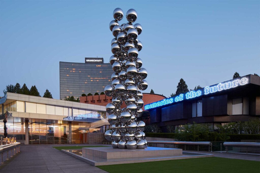 Exterior view of Leeum, Samsung Museum of Art at dusk in Seoul, South Korea, featuring Anish Kapoor's “Tall Tree and the Eye” sculpture in the foreground.
