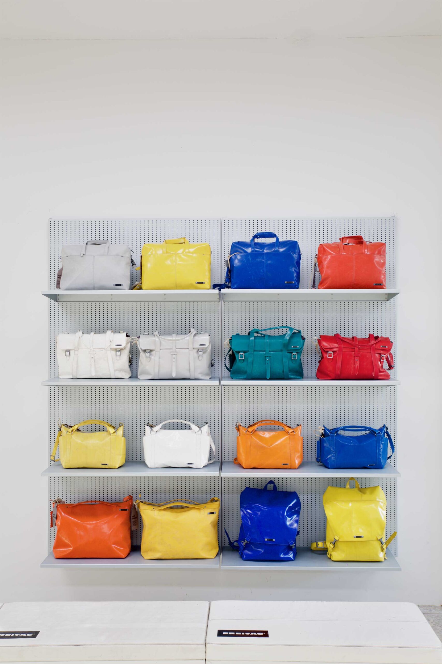 Shelf at Freitag MMMG Seoul, South Korea, store carefully arranged with a vibrant selection of bags in various colors.