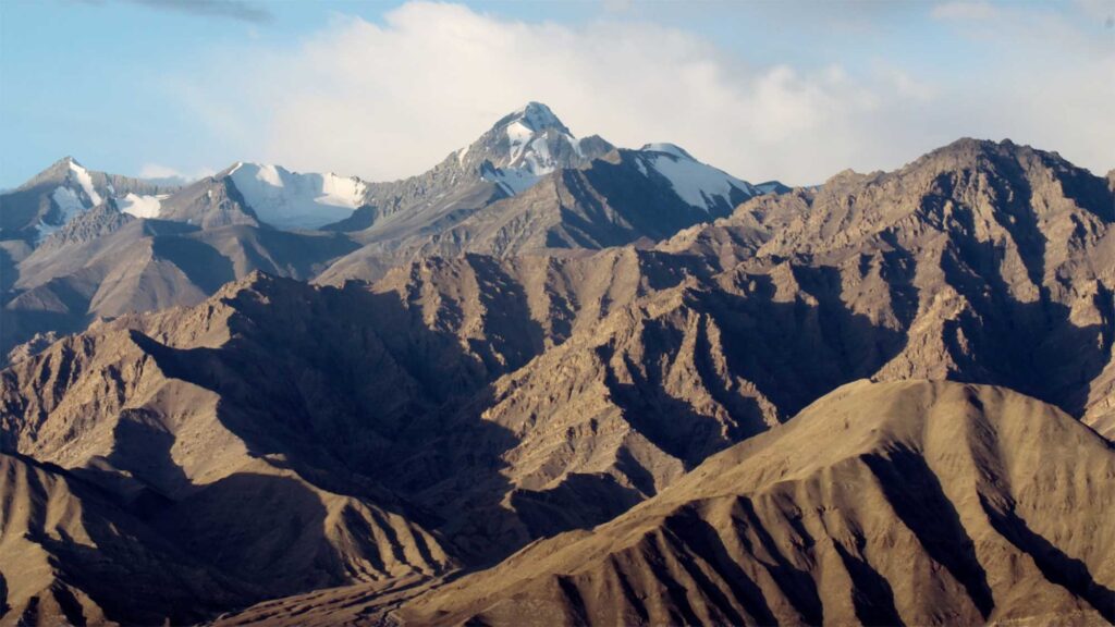 Snow-capped peaks of the Himalayas rise over the breathtaking landscape of Ladakh, India.