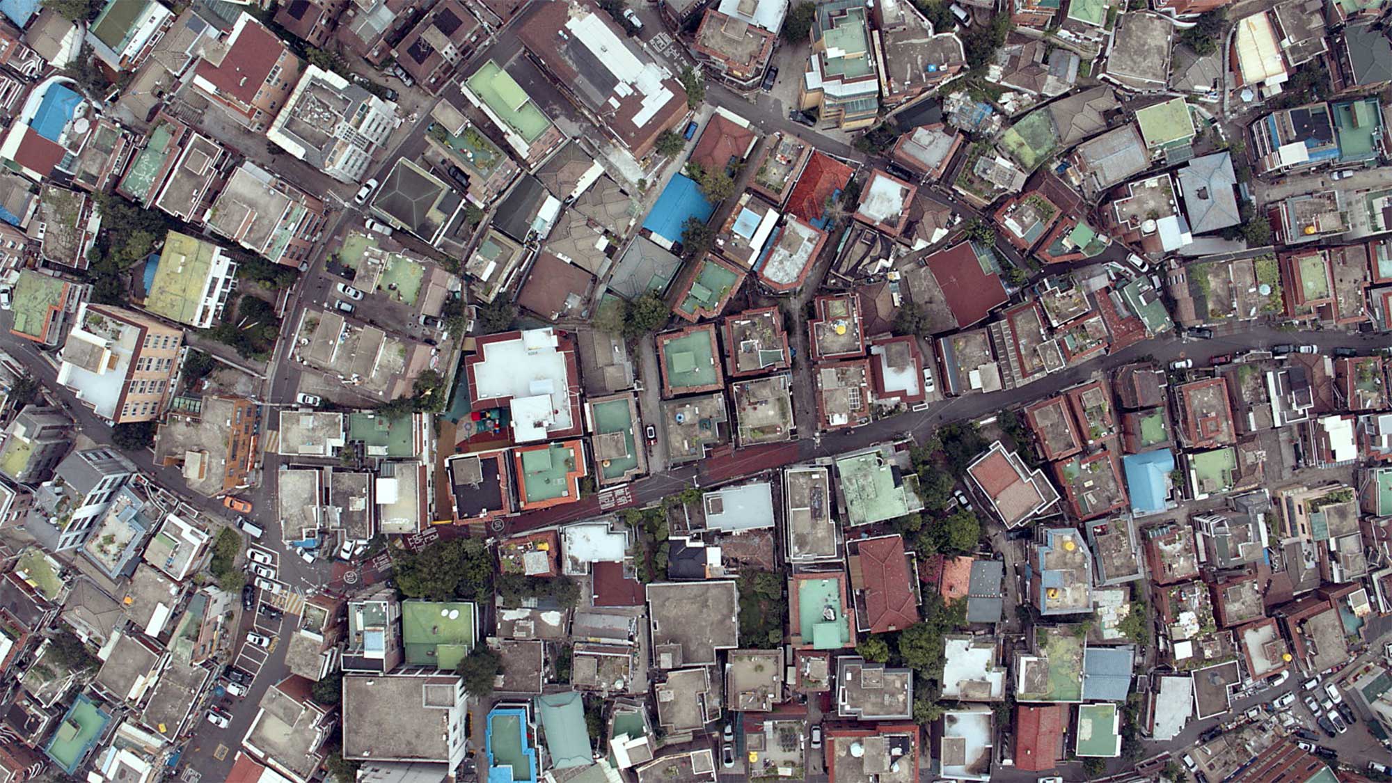 Drone shot from bird's-eye perspective looking down on older neighborhood in Seoul, South Korea.