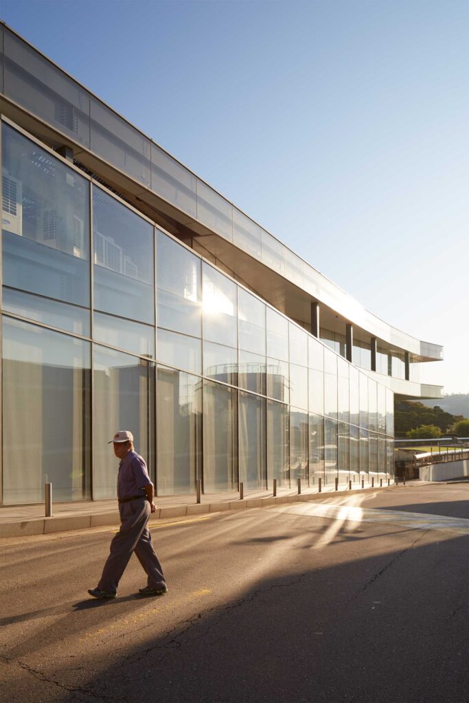 A man crosses the street beside the glass facade of Samsung Child Education & Culture Center, designed by Rem Koolhaas, at Leeum, Samsung Museum of Art in Seoul, South Korea.