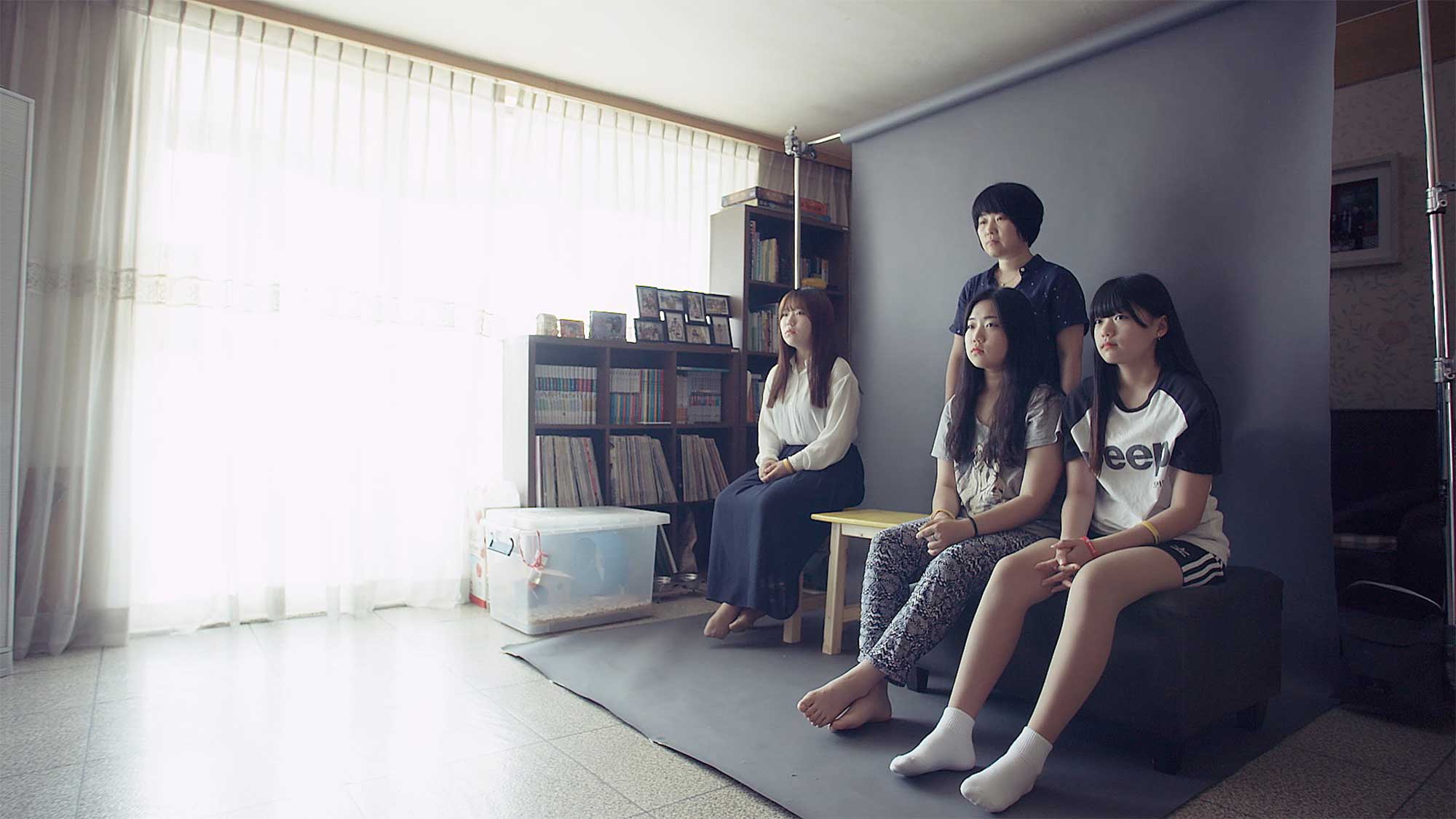 A mother and her three daughters pose for a portrait, leaving an empty chair for her fourth daughter, who was among the many lives lost in the Sewol ferry disaster in South Korea