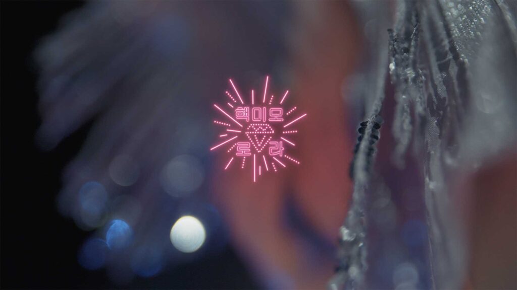 Close-up of blurred décolleté of plastic doll with human traits, with graphic overlay displaying her name Laura and characteristic Extreme Beauty, as part of film Plastic Girls in Seoul, South Korea.