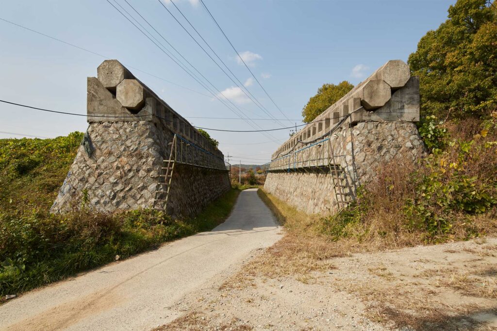 Demolition barriers positioned on either side of a rural road that runs along the former civilian control line in the Korean Demilitarized Zone, South Korea.