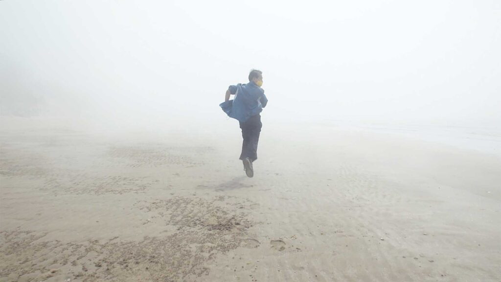 A man runs away from the camera on a fog-covered, lonely beach, resembling one of the lost souls of the Sewol ferry disaster in this dream sequence for the short film Last Letters.