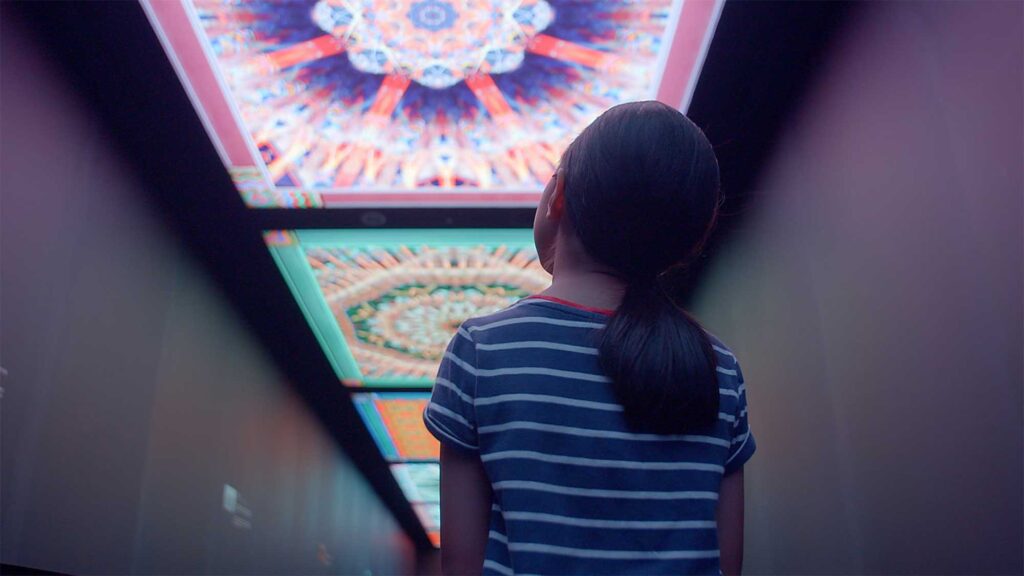 Girl walks through colorful alley leading up to elevator of Lotte Tower in Seoul, South Korea.