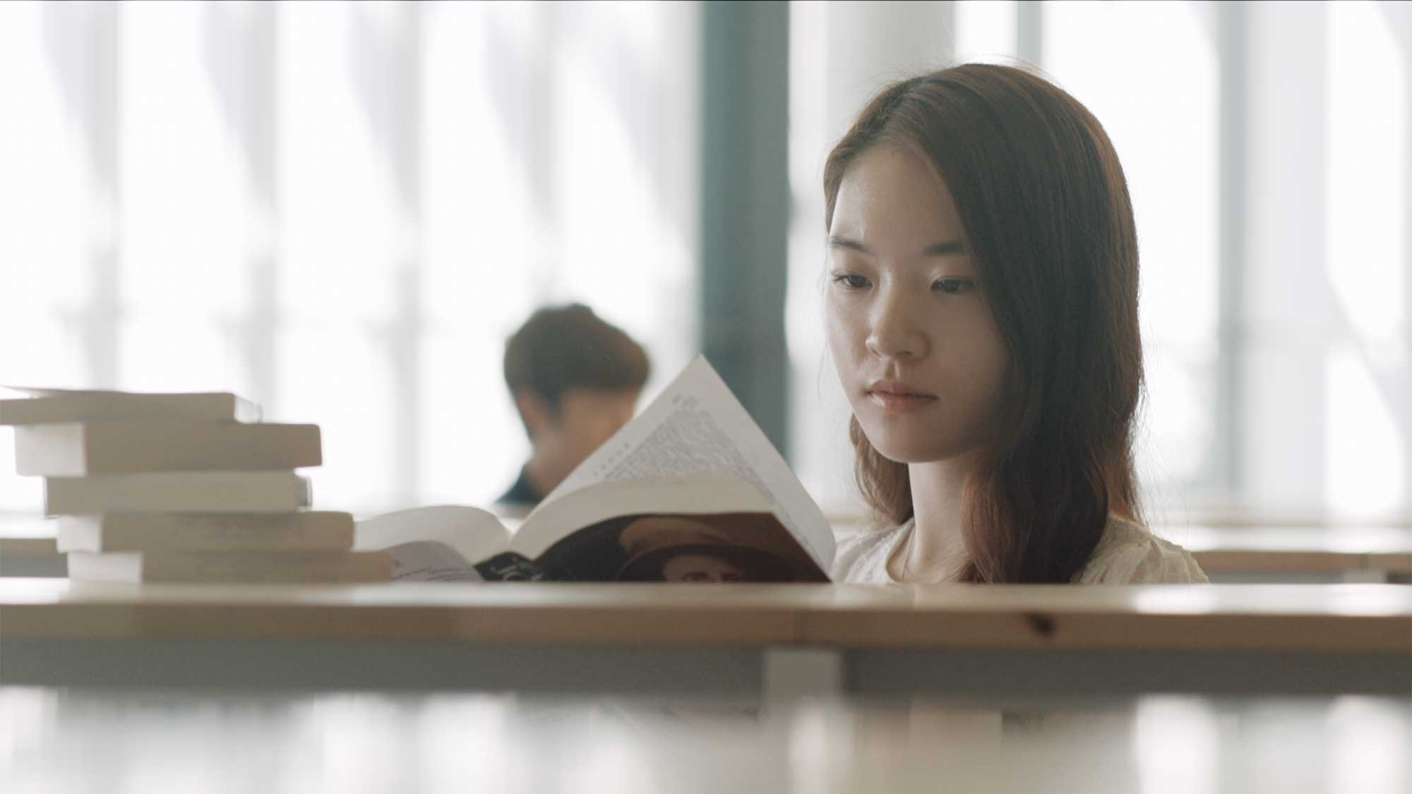 An Underwood International College student in the library at Yonsei University Songdo campus, searching for the perfect book.