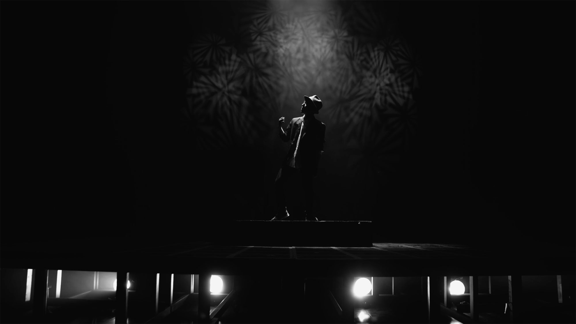 Korean singer performing on stage with dramatic lighting in Seoul, South Korea, for music video "Beautiful Woman" from Tune-Up Joong-Hyun Shin: Origin tribute album.